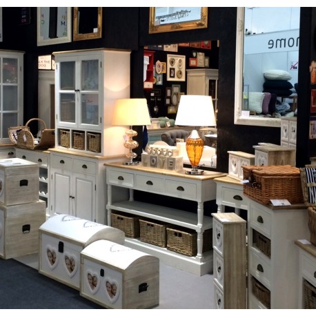 Białe meble prowansalskie z brązowymi koszami zamiast szuflad to ciekawe i oryginalne rozwiązanie.