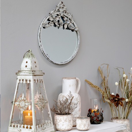 Okrągłe lustro prowansalskie w ramie z postarzeniami i z ozdobnym dekorem wieńczącym jego górną część - to model idealny dla Ciebie!