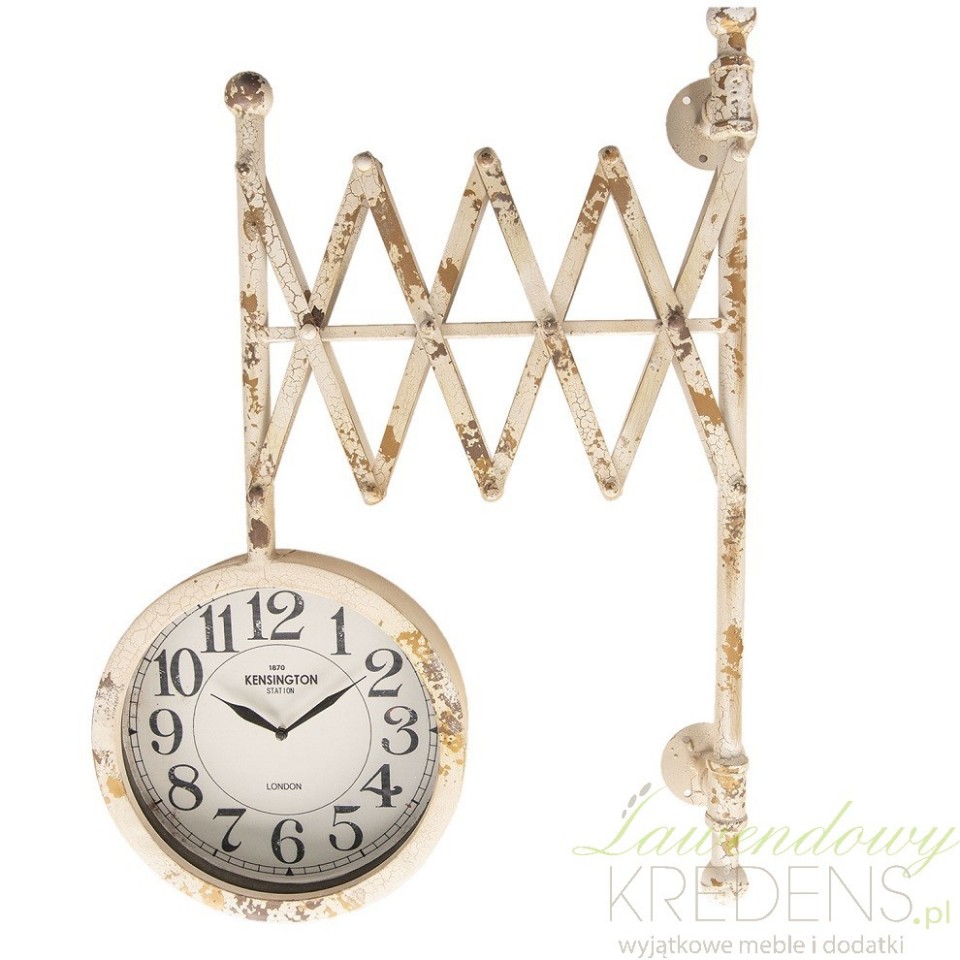 Dwustronny zegar ścienny z metalu posiada uchwyt w formie harmonijki. Zdobią go liczne odpryski.