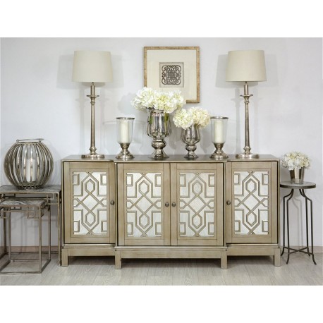 Duża, pojemna komoda Avola z czteroma drzwiami, które zostały udekorowane kształtnymi figurami geometrycznymi.