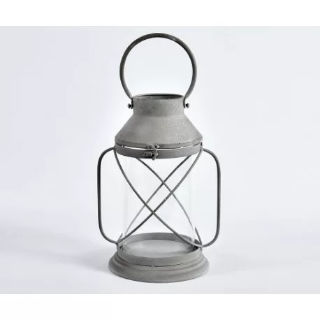 Lampion latarnia ze szklanym naczyniem na świeczkę oraz poręcznym, zaokrąglonym uchwytem. Jest metalowy. 