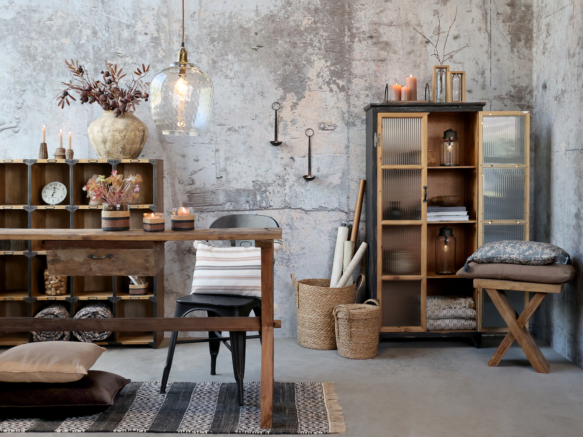 Wnętrze w stylu vintage z drewnianymi meblami, industrialnymi dodatkami i nastrojowym światłem świec tworzy klimat pełen ciepła i charakteru.